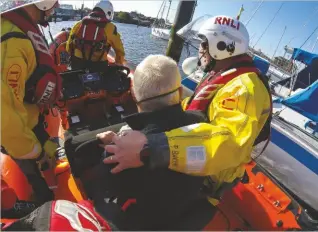  ??  ?? Martin is assisted aboard Lymington’s Atlantic 85 inshore lifeboat David Bradley