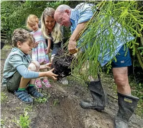 ?? ROBERT KITCHIN, MONIQUE FORD AND KEVIN STENT/STUFF ?? Miriam Freeman-Plume, of Plimmerton, made a New Year’s resolution to plant 365 trees this year. She is helped out by her children Josh, 9, and Tovi, 4, and husband Russell.