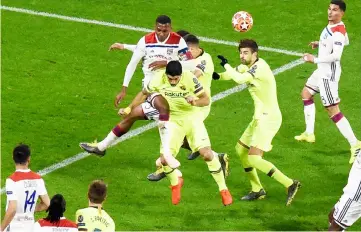  ??  ?? Lyon’s defender Marcelo (centre, top) and Barcelona’s Uruguayan forward Luis Suarez try to head the ball next to Barcelona’s defender Gerard Pique (centre, right) during the UEFA Champions League round of 16 first leg match at the Groupama Stadium in Decines-Charpieu, central-eastern France. — AFP photo