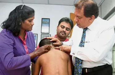  ??  ?? Painful experience: Suraya Fatima (left) showing Muhammad Resan’s scars to lawyer Gerard Lazarus during the press conference in Klang. Looking on is the boy’s father, M.D. Ekramul.