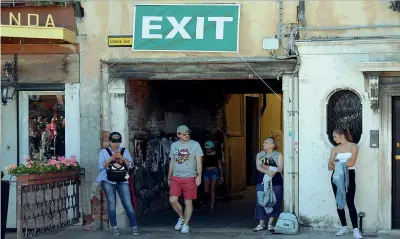  ??  ?? Venezia con i cartelli «Exit» per indicare le vie di fuga durante la festa del Redentore: è la prima volta che si sperimenta il numero chiuso