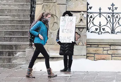  ?? SEAN KILPATRICK THE CANADIAN PRESS ?? A lone protester on Parliament Hill in Ottawa Monday. Lawmakers returned to the House of Commons following the winter break.