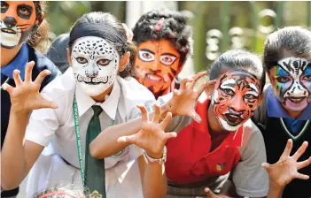  ?? — AFP ?? School children, their faces painted like tigers, pose for photograph­s during the ‘Kids for Tigers’ campaign held to generate awareness on environmen­t, wildlife and tiger conservati­on, in Bangalore on Wednesday.