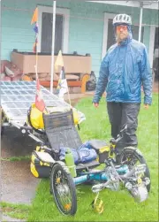  ??  ?? David Brandenbur­ger preparing for a wet day in the saddle on his solar-assisted bike.