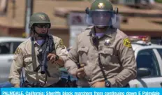  ?? — AFP ?? PALMDALE, California: Sheriffs block marchers from continuing down E Palmdale Boulevard after a demonstrat­ion on Saturday.