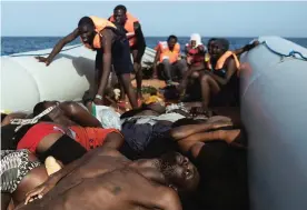  ??  ?? AT SEA: Graphic content / Migrants step over dead bodies while being rescued by members of Proactiva Open Arms NGO in the Mediterran­ean Sea, some 12 nautical miles north of Libya, on October 4, 2016. —AFP