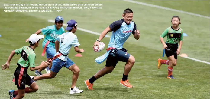  ??  ?? Japanese rugby star Ayumu Goromaru (second right) plays with children before the opening ceremony of Kamaishi Recovery Memorial Stadium, also known as Kamaishi Unosumai Memorial Stadium. — AFP