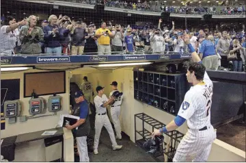  ?? AP - Aaron Gash, file ?? Fans cheer as the Brewers’ Christian Yelich walks off the field after driving in the winning run during the ninth inning of a game against the Cubs last season. Yelich is one of the players in favor of a rule in place for the 2020 season, in which a runner will be placed on second base to begin each extra inning.