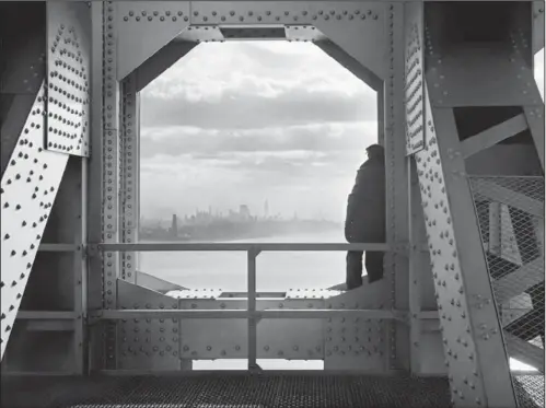  ??  ?? SKYLINE: In this Dec. 22, 1936, Works Progress Administra­tion photo provided by the New York City Municipal Archives, a man looks at the Hudson River from the New York tower of the George Washington Bridge. Over 870,000 photos from an archive that...