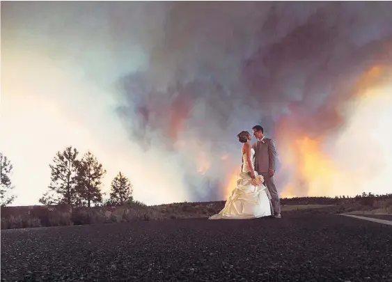  ?? Picture / AP ?? Michael Wolber and April Hartley had to cut short their ceremony and evacuate their wedding venue because of the approachin­g bushfire.