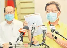  ?? — Photo by
Chimon Upon ?? Dr Sim (right) shows the list to reporters as Uggah (le ) looks on.