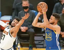  ?? KYLE TERADA/USA TODAY SPORTS ?? Warriors guard Stephen Curry (30) shoots as Nuggets guard Jamal Murray (27) defends on Monday in San Francisco. Curry finished with 53 points in a 116-107 Golden State victory.