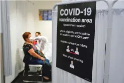  ?? MARCIO JOSE SANCHEZ/ASSOCIATED PRESS ?? A patient receives a shot of the Moderna COVID-19 vaccine Monday at a CVS Pharmacy branch in Los Angeles. Because Johnson & Johnson’s single-shot vaccine is easier to store and use than Moderna’s or Pfizer’s, it could wind up primarily in underserve­d areas, creating perception­s of a two-tiered system.