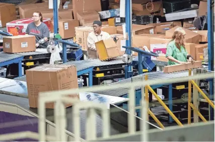  ?? Memphis Commercial Appeal | USA TODAY NETWORK – TENNESSEE MAX GERSH/THE COMMERCIAL APPEAL ?? Employees sort packages before Christmas at the Fedex Ground Olive Branch hub.