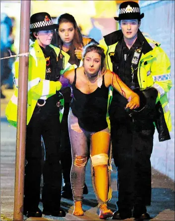  ?? DP=-BILD: GOODM=N ?? Zwei Polizistin­nen helfen an der Manchester =rena einer verletzten Frau.