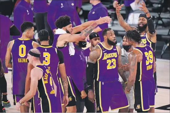  ?? L eBRON JAMES Mark J. Terrill Associated Press ?? is in the center of the huddle, and with a triple-double, he was at the center of the Lakers’ Western Conference-clinching victory over the Nuggets.