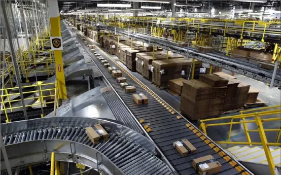  ?? Associated Press ?? Packages ride on a conveyor system at an Amazon fulfillmen­t center in Baltimore. Amazon, Walmart and others are promising to deliver more of their goods in a day. This holiday season will be the first real test of whether they can make that happen.