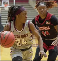  ?? (Photo courtesy UALR Athletics) ?? UALR’s Teal Battle works her way around Louisiana-Lafayette’s Jomyra Mathis on Monday at the Jack Stephens Center in Little Rock. Battle had six points for the Trojans, who lost 54-45.
