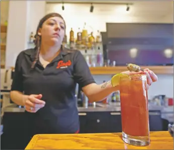  ?? LUIS SÁNCHEZ SATURNO/The New Mexican ?? Maryssa Esquibel, manager at Joe’s Dining, finishes making a Bloody Mary in March. The revamped state liquor license laws that made it cheaper and easier for smaller restaurant­s to apply for a liquor license have been ‘wildly successful’ so far, the director of the state Alcoholic Beverage Control Division said Monday.