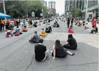  ?? JOHN RENNISON THE HAMILTON SPECTATOR ?? Protesters stage a sit-in on Main Street near city hall Monday before a HamiltonWe­ntworth District School Board vote on policing in schools.