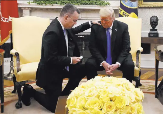  ?? Jacquelyn Martin The Associated Press ?? President Donald Trump prays Saturday with American pastor Andrew Brunson in the Oval Office. Brunson was freed Friday from nearly two years of detention in Turkey.