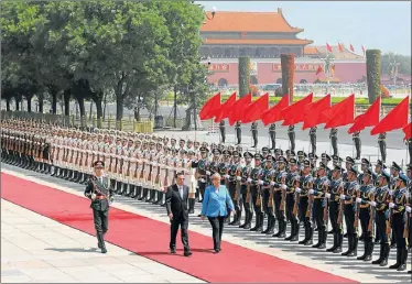  ?? FOTOS: AP ?? DOS POTENCIAS SE SALUDAN. Angela Merkel fue recibida con honores en la zona de Tiananmen.