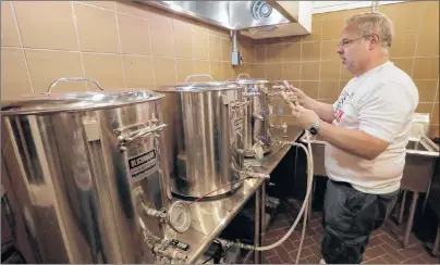  ?? AP PHOTO ?? Steve Clemens works on a batch of beer in his home basement brewery in Lodi, Wis. For many home brewers, having a dedicated space for brewing is both practical and fun and creating such a space requires some creativity.