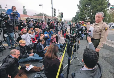  ?? Reuters; AP ?? Ventura County Sheriff Geoff Dean at a news conference after the mass shooting at a bar in Thousand Oaks, California, above, while right, forensics officers at the scene where the gunman opened fire in a bar crowded with hundreds of people