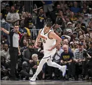  ?? AARON ONTIVEROZ — THE DENVER POST ?? Nikola Jokic humbly reacts to dunking on Victor Wembanyama as fans rejoice during the first quarter at Ball Arena in Denver on Tuesday.