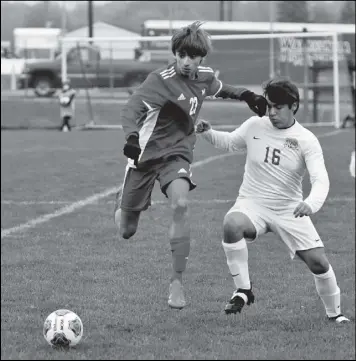 ?? Photo by John Zwez ?? Connor Lause of Wapakoneta, left, jumps toward the ball with Defiance’s Vinnie Lopez nearby during Monday’s sectional playoff game.