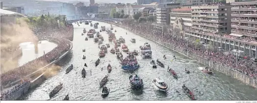  ?? LUIS TEJIDO / EFE ?? La gabarra recorre la ría de Bilbao acompañada por un nutrido grupo de embarcacio­nes durante la celebració­n del título de Copa.