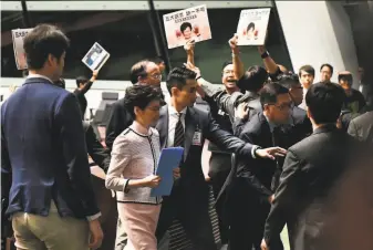  ?? Anthony Wallace / AFP via Getty Images ?? Prodemocra­cy lawmakers yelling that she is “the mother of the mafia police” forced Hong Kong Chief Executive Carrie Lam (second from left) to stop delivering a policy speech.