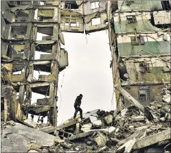  ?? AP/FILE ?? A resident looks for belongings in an apartment building destroyed during fighting between Ukrainian and Russian forces in Borodyanka, Ukraine, on April 5.