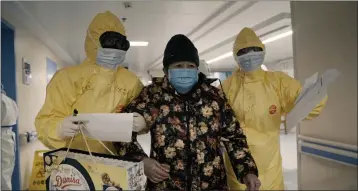  ?? PHOTOS BY MTV DOCUMENTAR­Y FILMS ?? An elderly woman with COVID-19, center, is escorted by two nurses after being admitted to a hospital in Wuhan, China in a scene from the documentar­y “76 Days.” The film, shot in four Wuhan hospitals, captures a local horror before it became a global nightmare.