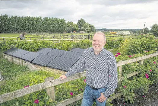  ??  ?? LEADING THE WAY: Garry Charnock, who started Ashton Hayes’ emissions-reduction movement, stands near some of the many solar panels in his village.