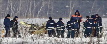  ??  ?? Personnel work at the scene of a AN-148 plane crash in Stepanovsk­oye village, about 25 miles from the Domodedovo airport, Russia on Moday. A Russian passenger plane carrying 71 people crashed Sunday near Moscow, killing everyone aboard shortly after...