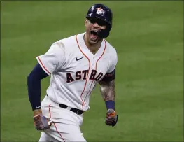  ?? KEVIN M. COX — THE GALVESTON COUNTY DAILY NEWS ?? The Houston Astros’ Carlos Correa screams toward his dugout after hitting a go-ahead solo home run off Boston Red Sox relief pitcher Hansel Robles in the bottom of the seventh inning of Game 1of the American League Championsh­ip Series on Friday in Houston.