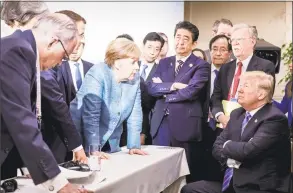  ?? Jesco Denzel / Associated Press ?? German Chancellor Angela Merkel, center, speaks with President Donald Trump, seated at right, during the G7 Leaders Summit in La Malbaie, Quebec, on Saturday.