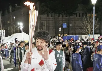  ?? The Yomiuri Shimbun ?? Profession­al basketball player Yuta Tabuse carries the Olympic torch in Utsunomiya on March 29.