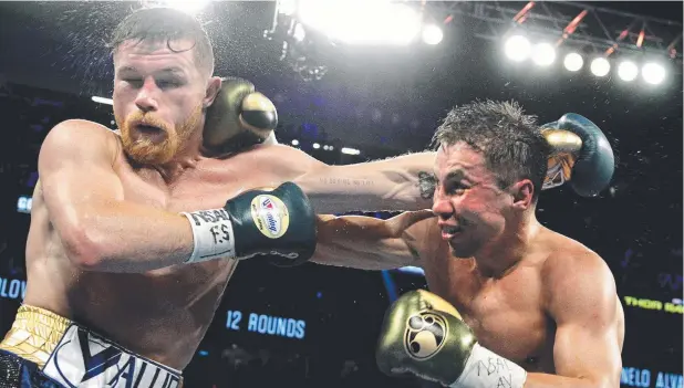  ?? Picture: AFP ?? EVENLY MATCHED: Gennady Golovkin (right) trades blows with Canelo Alvarez during their WBC, WBA and IBF middleweig­ht championsh­ip fight in Las Vegas.