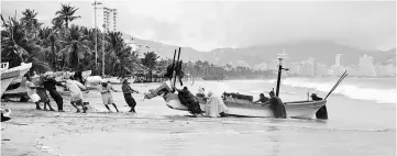  ??  ?? Fishermen take their boats out of the sea in anticipati­on of the arrival of Hurricane Max in Acapulco, Guerrero state, Mexico. — AFP photo