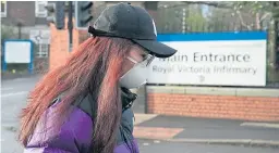  ?? Picture: PA. ?? A woman wears a mask outside Royal Victoria Infirmary in Newcastle Upon Tyne where two patients are currently being treated for coronaviru­s.