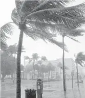  ?? WILFREDO LEE/AP ?? A normally bustling Ocean Drive is shown during a downpour Nov. 8 on Miami Beach’s famed South Beach.