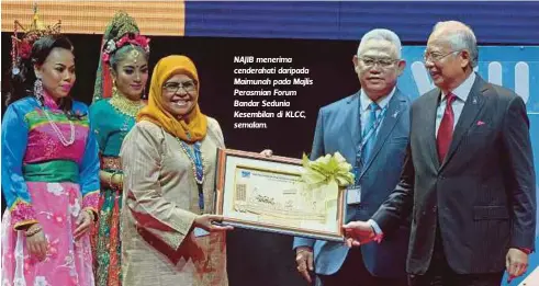  ?? FOTO: HAFIZIE SHABUDIN ?? NAJIB menerima cenderahat­i daripada Maimunah pada Majlis Perasmian Forum Bandar Sedunia Kesembilan di KLCC, semalam.