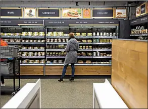  ?? Bloomberg News/MIKE KANE ?? An Amazon.com Inc. employee shops for prepared food last at an Amazon Go store in Seattle as the retailer tested the cashierles­s concept.