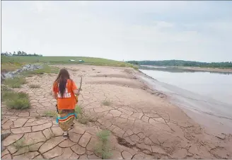  ?? CP PHOTO ?? Mi’kmaq activist Dorene Bernard walks on the shores of the Shubenacad­ie River, a 72-kilometre tidal river that cuts through the middle of Nova Scotia and flows into the Bay of Fundy, in Fort Ellis, N.S. on July 31.