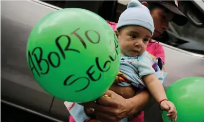  ?? ?? A man carries his son during a protest to mark Internatio­nal Women’s Day outside the public prosecutor’s office in Tegucigalp­a, Honduras. Photograph: Jorge Cabrera/Reuters