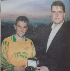  ??  ?? Mark Doyle of Rathnew receives his man of the match award from Denis Grant of the Mayfair Hotel after the 1998 Wicklow Cup final.