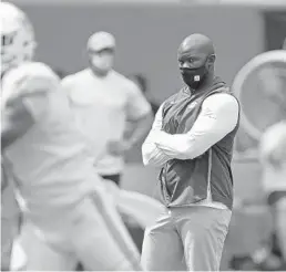  ?? JOHN MCCALL/SOUTH FLORIDA SUN SENTINEL ?? Dolphins coach Brian Flores watches quarterbac­k Tua Tagovailoa warm up before their game against the Seahawks at Hard Rock Stadium on Sunday.