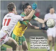  ??  ?? TOO SHARP: Donegal’s Martin O’reilly offloads as Tyrone’s Kieran Mcgeary closes in
